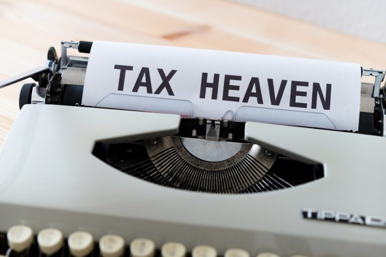 A person sorting tax paperwork into labeled folders at a tidy home desk.